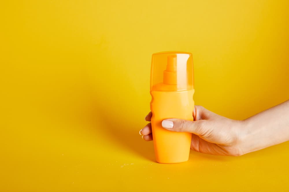 Cropped view of woman holding sunscreen