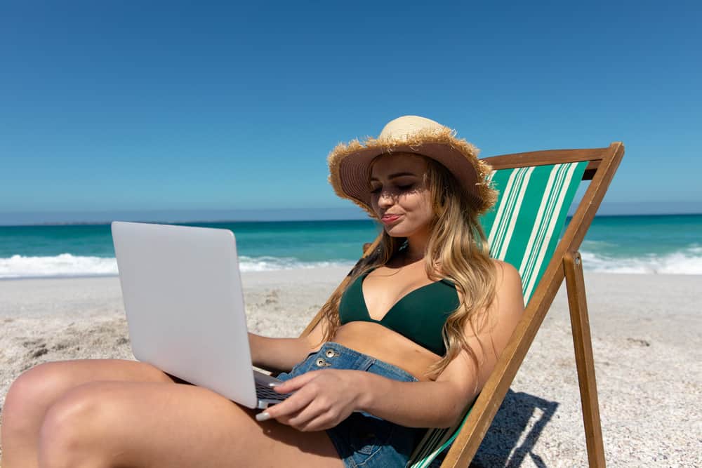 Side view of a Caucasian woman sitting and using laptop