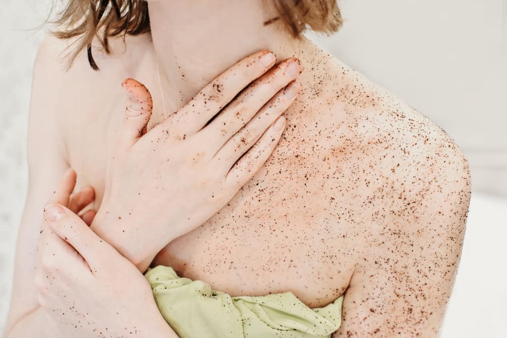 woman applying body exfoliating scrub